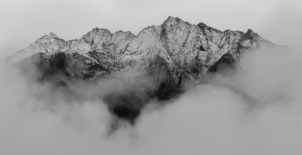 Black and white image of a mountain peak rising above clouds, symbolizing strong foundations and growth in WordPress SEO Basics.